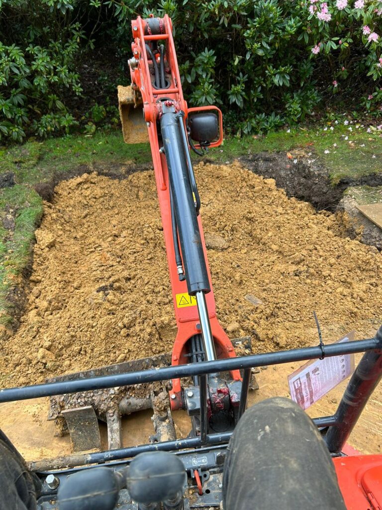 Mini digger carrying out residential drain repair and excavation work