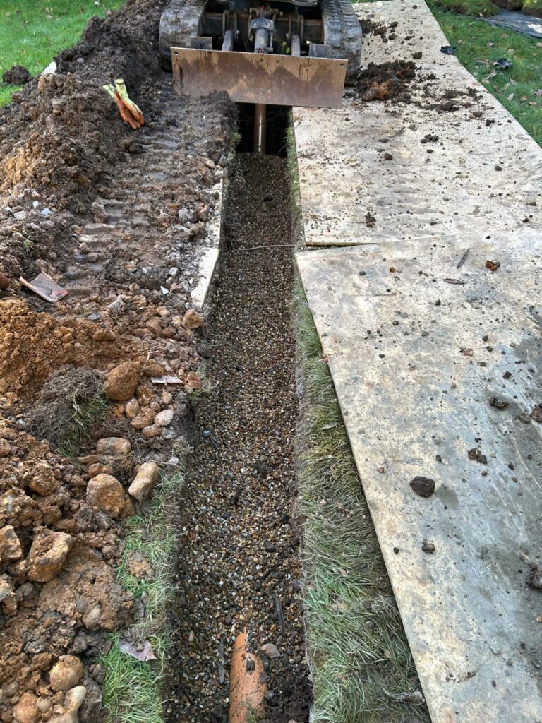 Emergency drain excavation exposing damaged underground pipework for repair and replacement.